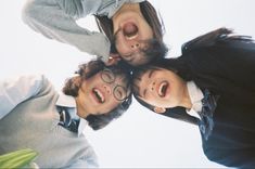 four people are standing in a circle with their mouths open and one is wearing glasses