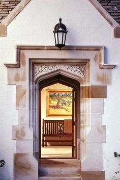 a wooden bench sitting in front of a white building with a painting on it's wall