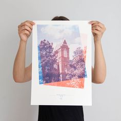 a person holding up a photo with trees in the background