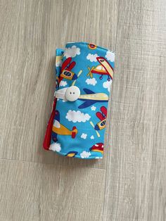 a small blue case with airplanes and clouds on it