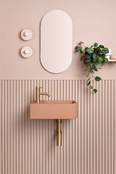 a bathroom with a sink, mirror and plant on the wall next to striped walls