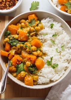 two bowls filled with rice, carrots and chickpeas