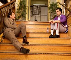 two men sitting on the steps talking to each other