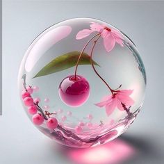 a glass ball with pink flowers and leaves in it