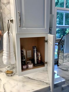 a bathroom with marble counter tops and white cabinets