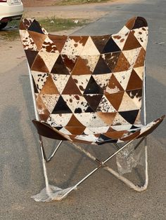 a brown and white chair sitting on the side of a road