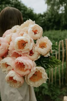 a woman holding a bouquet of flowers in her hands