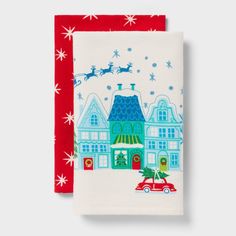 two christmas napkins with santa's sleigh and houses on the front