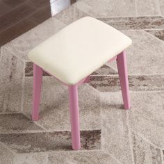 a pink and white stool sitting on top of a rug