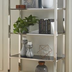 a white shelf filled with books and vases on top of it's shelves