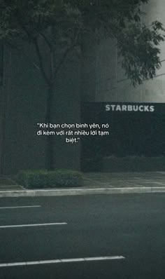 an empty parking lot next to a tall building with the words starbucks written on it