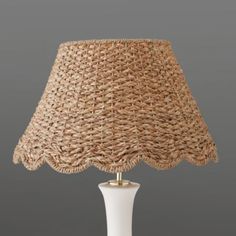 a white table lamp with wicker shade