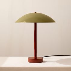 a green lamp on a table with a white background