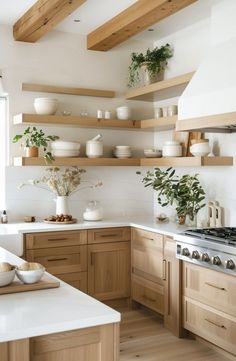 a kitchen filled with lots of wooden shelves and white counter tops next to a stove top oven