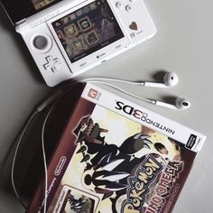 two nintendo wii games sitting next to each other on top of a white table with headphones