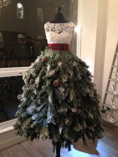 a dress made out of pine cones and snow flakes is displayed on a mannequin