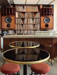 a table with two stools in front of it and some bookshelves behind it