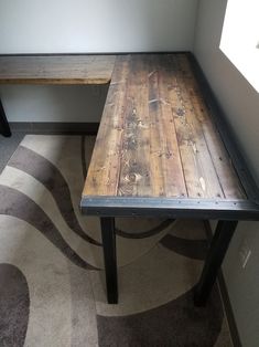 a wooden table sitting next to a metal bench on top of a carpeted floor