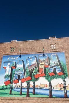 a large mural on the side of a building that says, city of tampa with palm trees