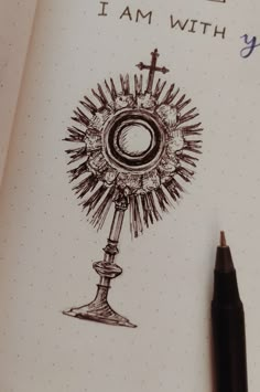 a pen is sitting on top of a notebook with an image of a cross and the words, i am with you