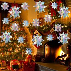 christmas decorations hanging from the ceiling in front of a fire place with presents under it