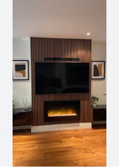 a living room with a large television mounted on the wall next to a fire place