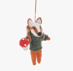 an ornament shaped like a fox hanging from a string with a mushroom on it