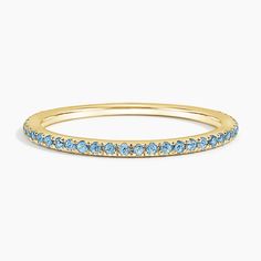 a yellow gold band with blue topaz stones