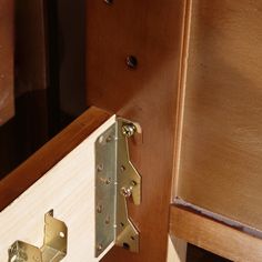 a close up of a door handle on a wooden cabinet