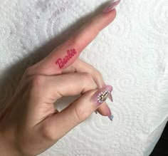 a woman's finger with the word barbie written on it