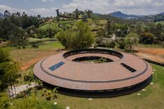 an aerial view of a circular building in the middle of a field