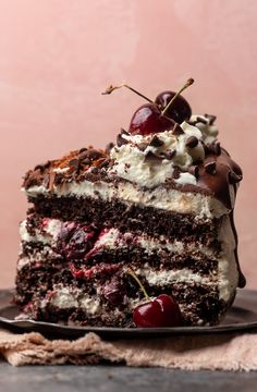 a piece of cake with chocolate and cherries on top