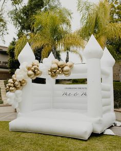 an inflatable wedding arch decorated with gold and white balloons