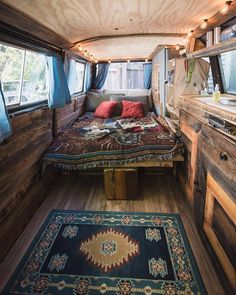 the interior of a camper with wood paneling and blue rugs on the floor