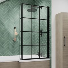 a bathroom with green tiles and a black frame shower head, toiletries and cabinet