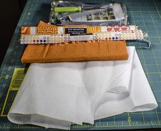 sewing supplies laid out on a cutting board with rulers, scissors and other items