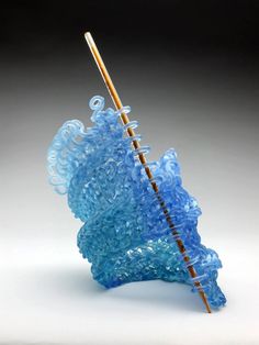 a blue glass object with a wooden stick sticking out of it