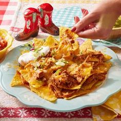 a plate full of nachos, salsa and guacamole on a table