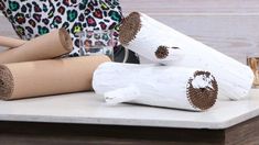 three rolled up logs sitting on top of a table next to some glasses and a leopard print purse