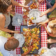 people are gathered around a table with food on it