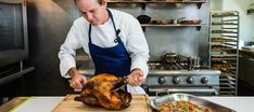 a man preparing food in a kitchen next to a turkey on a wooden cutting board