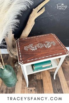 a wooden table sitting on top of a hard wood floor next to a green vase