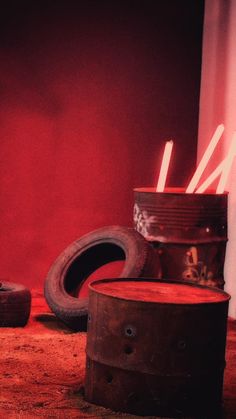 an old barrel with candles in it sitting on the floor next to other items that have been placed around