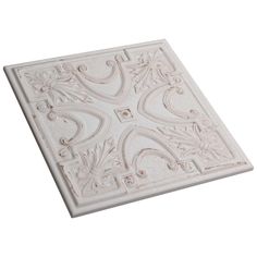 a white tile with an intricate design on the top and bottom, against a white background