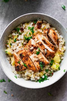 grilled chicken and rice in a bowl with parsley garnish on top