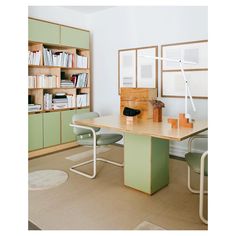 a room with a table, chairs and bookshelves