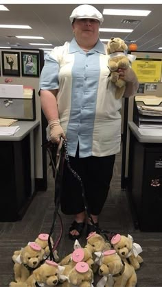 a woman holding two teddy bears in her hands while standing next to piles of stuffed animals