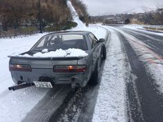 a car that is sitting in the snow with it's front end smashed off