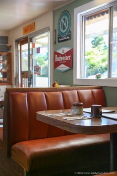 the inside of a restaurant with booths and tables