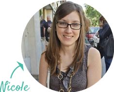 a woman with glasses and a necklace in front of a sign that says nicole on it